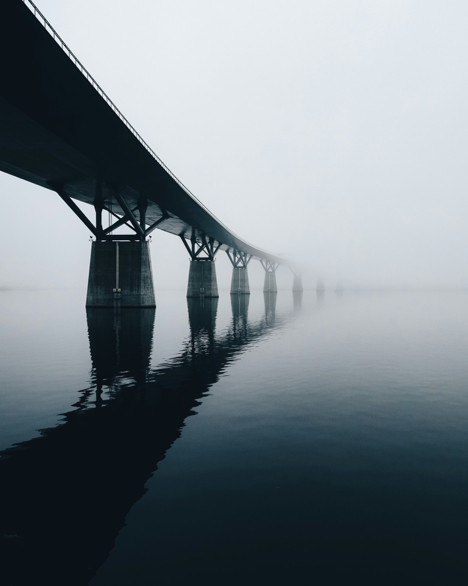 Bridge disappearing into fog symbolizing dual perspective