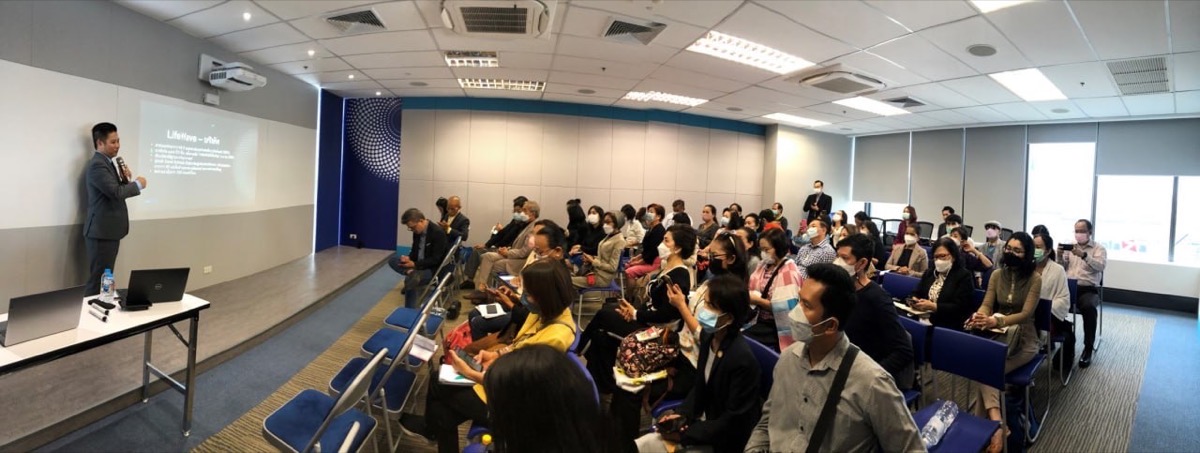 Mikael Chew speaking to a large audience