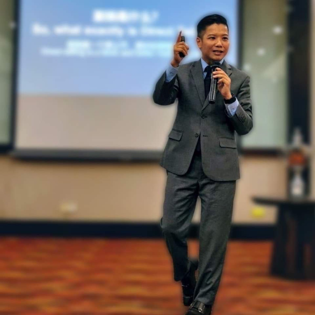 Mikael Chew speaking on stage