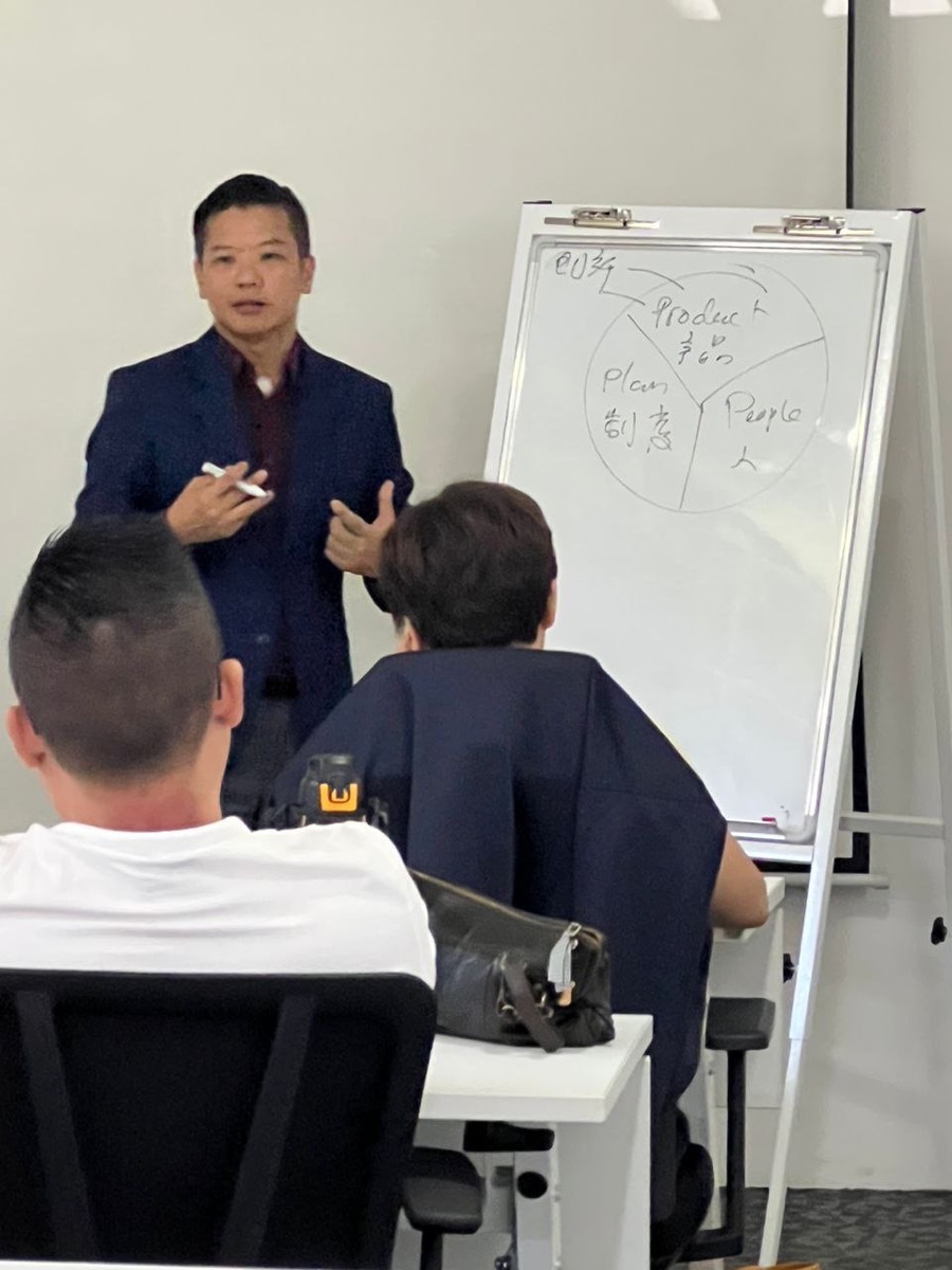Mikael Chew teaching at whiteboard